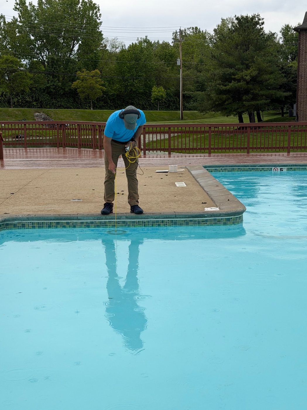 Technician using LeakTronics equipment to listen to pool fittings, returns, and skimmers